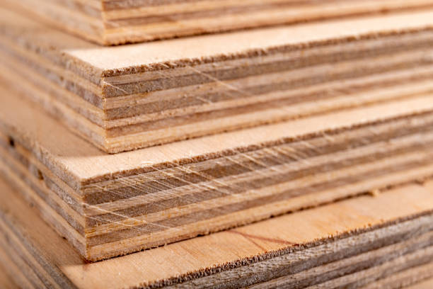 Plywood panels stacked on top of each other. Materials for carpenters for the construction of furniture. Dark background.